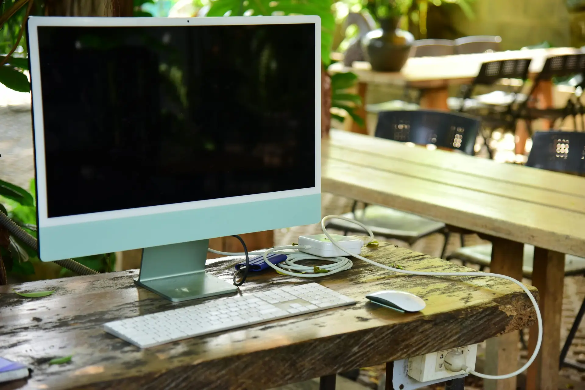 Modern computer setup on a rustic table outdoors, perfect for remote work.